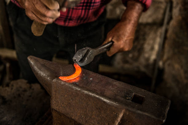 istock Senior Blacksmith Man Forging a Curved Knife on Anvil 832254474