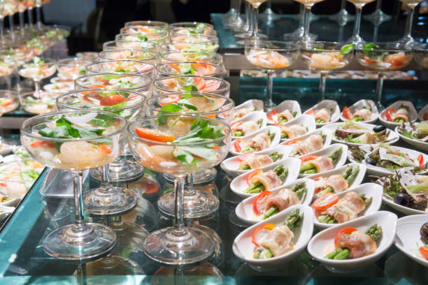 istock buffet shrimp cocktail in wine glasses with Bacon wrapped asparagus 832255910