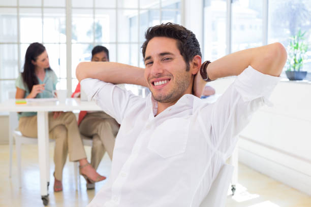 istock Businessman relaxing with coworkers in background 832256168