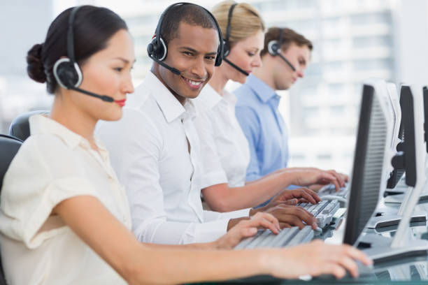 istock Business colleagues with headsets using computers at desk 832260862
