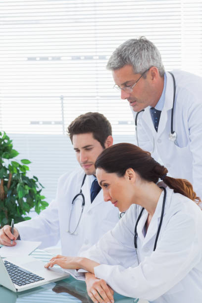 istock Team of doctors working together and watching something on their laptop 832265540