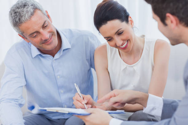 istock Smiling woman sign on a contrat with her partnership on sofa 832268100