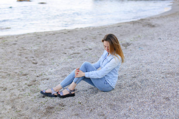 istock Smiling young woman rests on beach and poses in camera, sitting 832275452
