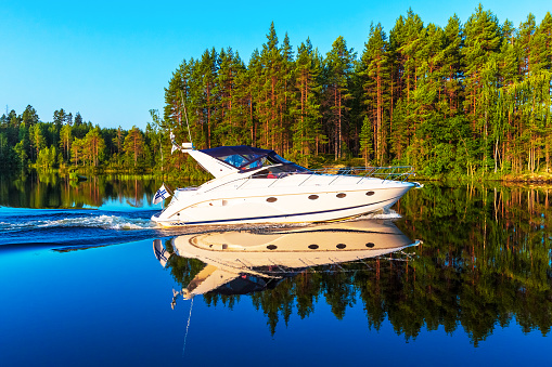 Scenic summer view of recreational yacht sailing by the lake water landscape among islands with deep forests in Finland