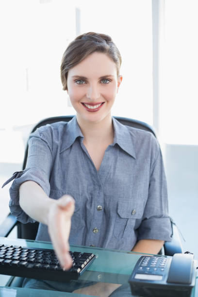 istock Friendly businesswoman welcoming while sitting at her desk 832298156