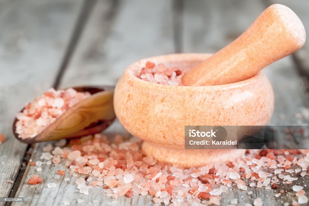 Pink himalayan salt Pink himalayan salt in wooden scoop and rose quarz mortare on old wooden background Salt - Mineral Stock Photo