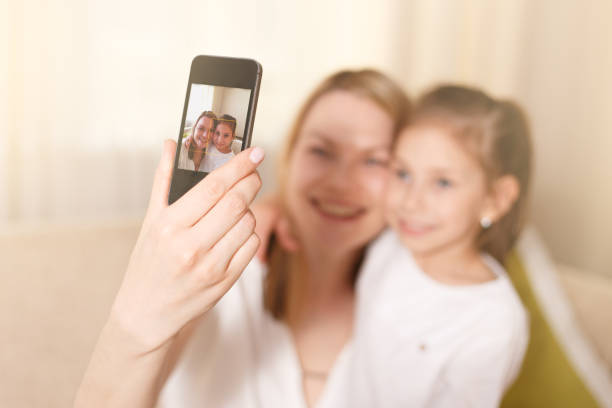 istock Beautiful mother and young daughter making a selfie. 832390278