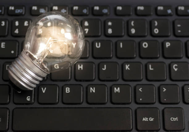 istock Lit light bulb lamp on top of a notebook computer black keyboard, technology concept and idea, with visible slightly out of focus keyboard letters. 832403858