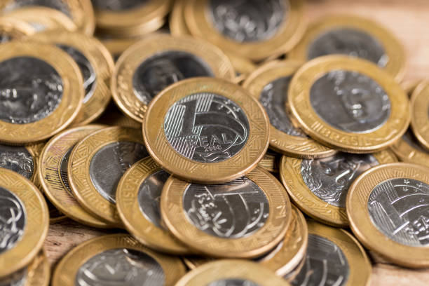 istock Several 1 real coins on a wooden table 832461106