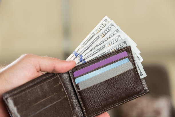 istock Wallet with 100 dollar bills in a man's hand 832462976