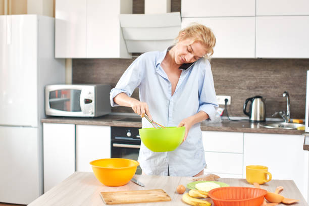 istock Young happy blond woman preparing dessert on white kitchen 832492702