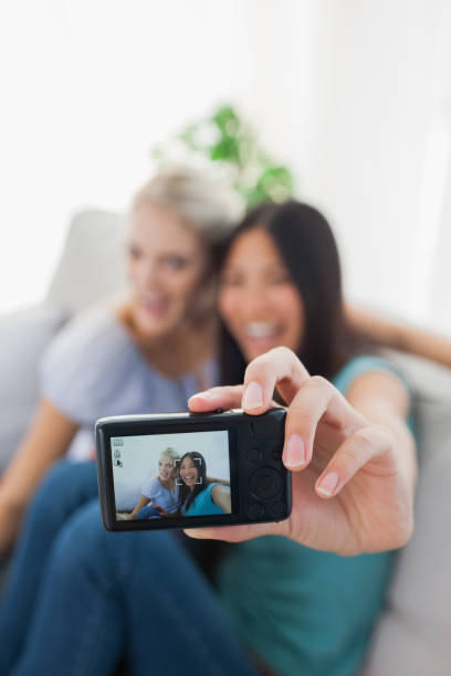 istock Two happy friends taking photo with camera 832499794