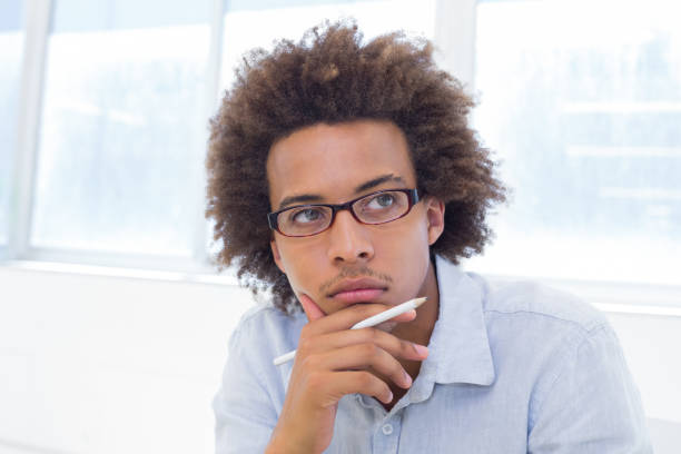 istock Attractive businessman thinking and holding a pencil 832509008