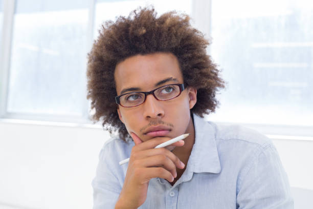 istock Attractive businessman thinking and holding a pencil 832509120