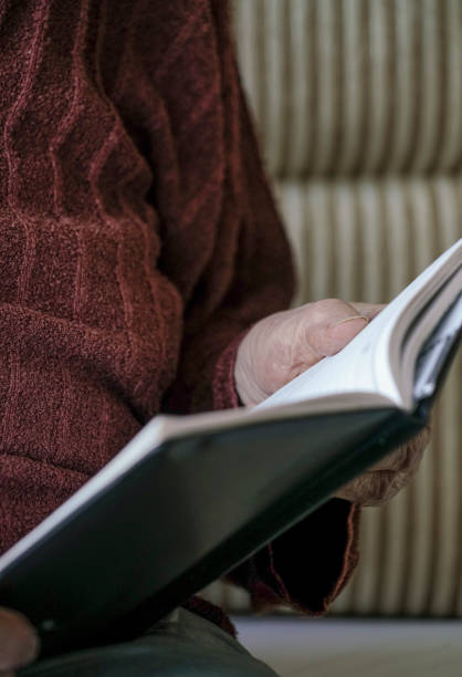 istock wrinkled hands of a person holding a book 832509166