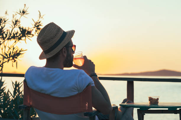 istock Young man enjoying sunset at a beach bar 832525776