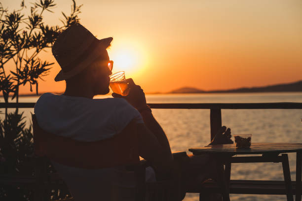 istock Young man enjoying sunset at a beach bar 832525804
