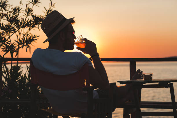 istock Young man enjoying sunset at a beach bar 832525818