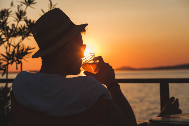 istock Young man enjoying sunset at a beach bar 832525826