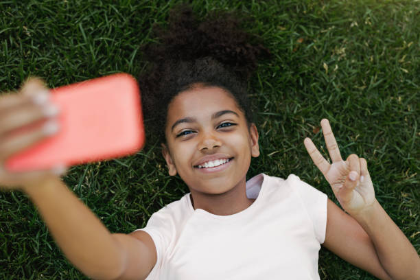 Smiling girl taking selfie on her smartphone