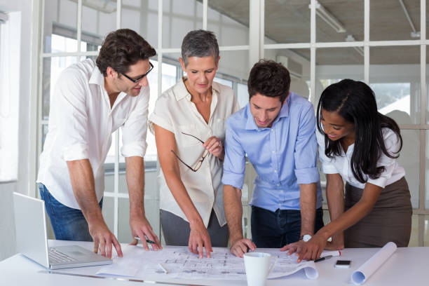 istock Attractive business people working hard on plans 832580462