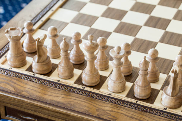 istock Wooden chess figures on a wooden   chessboard. 832580640