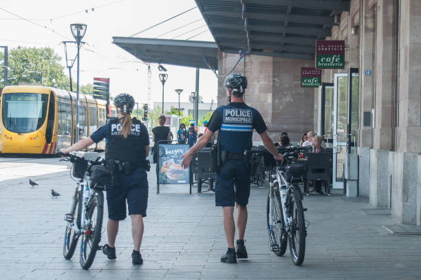 Municipal police patrolling by mountain bike in front of the train station Mulhouse - France - 14 June 2017 - Municipal police patrolling by mountain bike in front of the train station mulhouse photos stock pictures, royalty-free photos & images