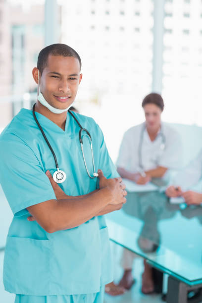 istock Surgeon standing with group around table in hospital 832597306