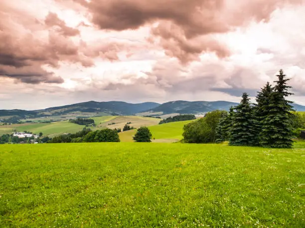 Green hilly landscape of Kralicky Sneznik area with dramatic stormy clouds, Czech Republic.