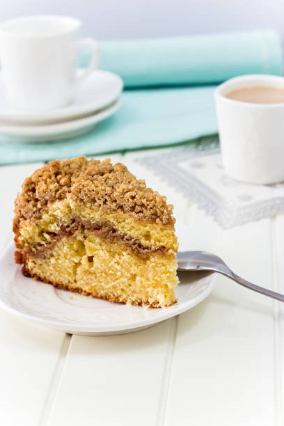 istock Cinnamon crumble coffee cake and cup of milk tea on white background 832609180
