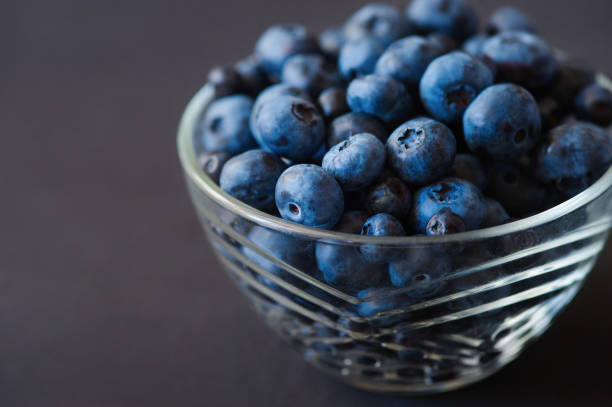 istock Fresh blueberries in white bowl on wood table, rustic style 832614170