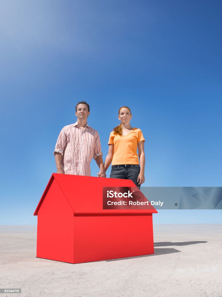 Casal em pé com pequena Casa modelo em deserto - Royalty-free Casa Foto de stock