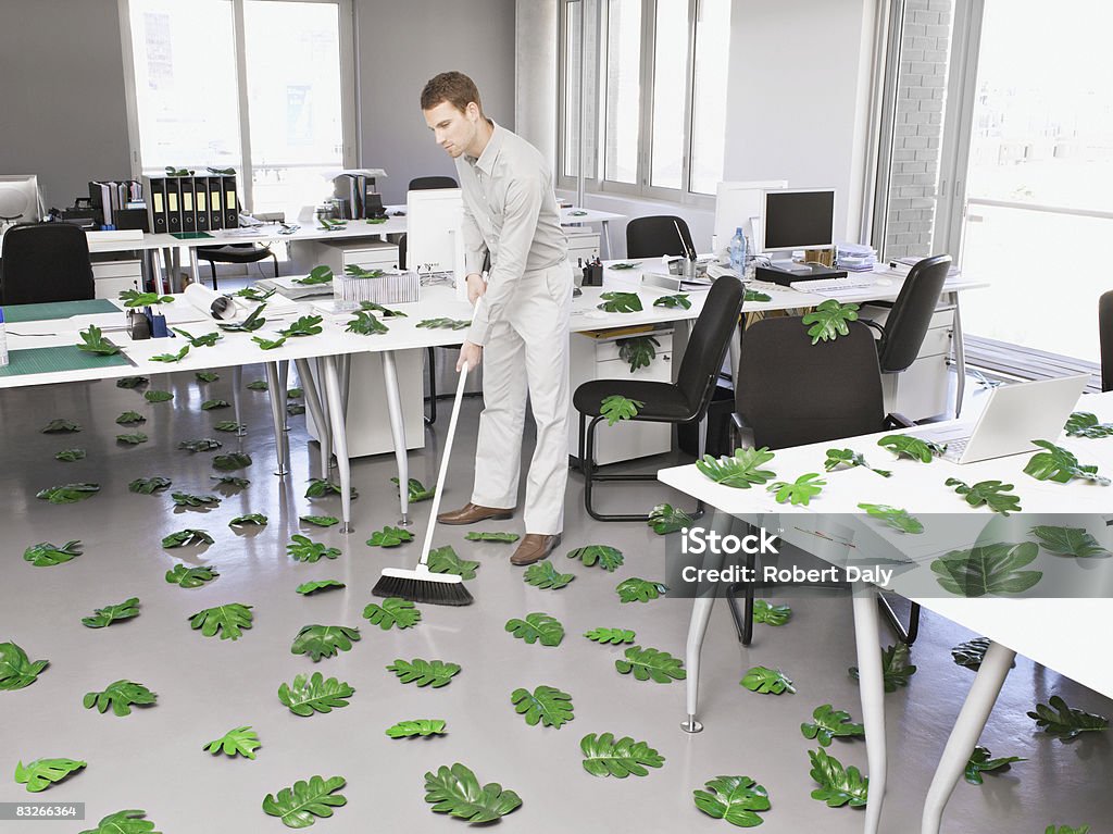 Empresario una hasta green leaves in office - Foto de stock de Limpiar libre de derechos