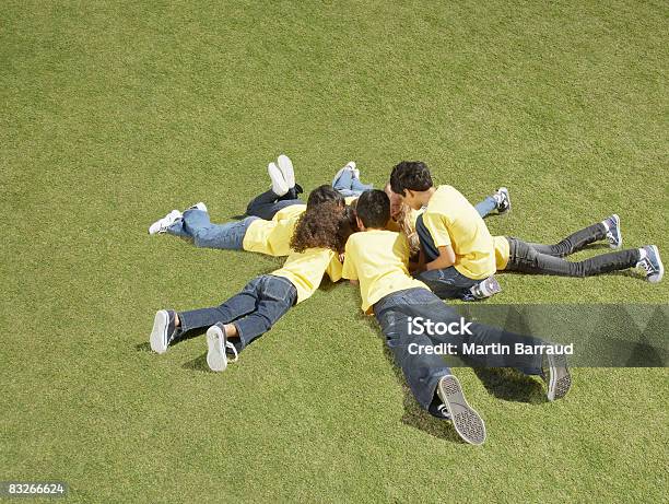 Grupo De Niños Que Descansan En La Hierba En Un Círculo Alrededor De La Formación Foto de stock y más banco de imágenes de 12-13 años