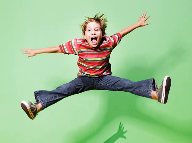 young boy ジャンプで空中 - 子供時代 ストックフォトと画像