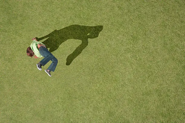 Photo of Young boy doing cartwheel in grass