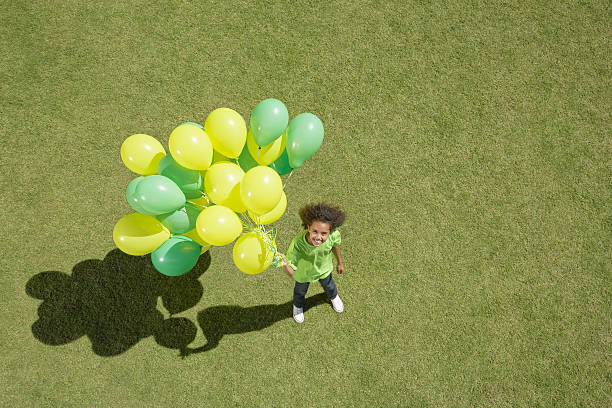 молодая девушка держит букет из номеров позиций - balloon child elementary age people стоковые фото и изображения