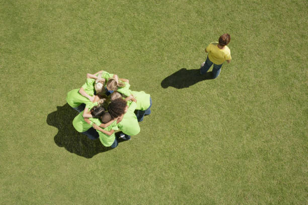 Group of children in huddle with one boy excluded  exclusion group of people separation fish out of water stock pictures, royalty-free photos & images