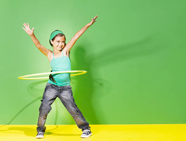 jeune fille jouant avec cerceau hula - white green indoors studio shot photos et images de collection