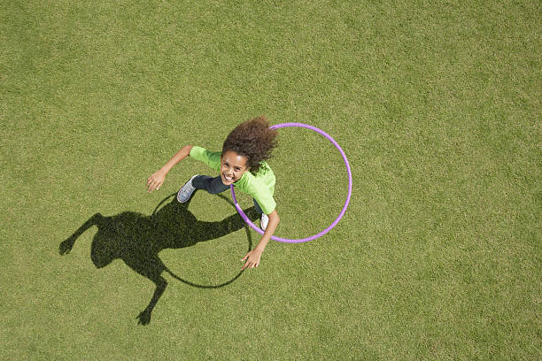 Young girl playing with hula hoop  playing alone stock pictures, royalty-free photos & images