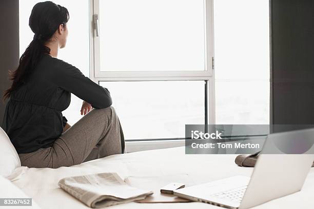 Businesswoman Sitting On Bed In Hotel Room Stock Photo - Download Image Now - 20-24 Years, Adult, Adults Only