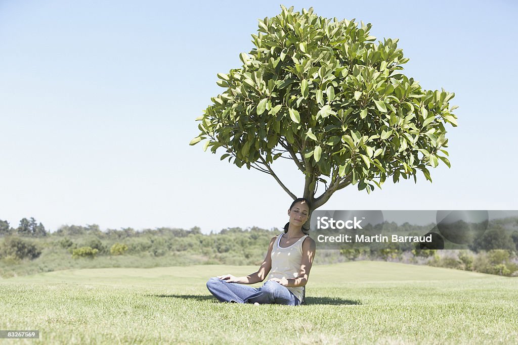 Mulher sentada Sombrear debaixo da árvore - Royalty-free Com sombra Foto de stock