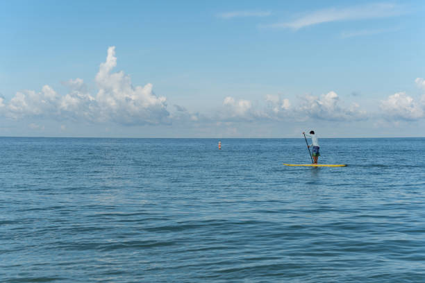 Clearwater, FL, USA - July21, 2017. Young man sails on stand up paddle board on the Gulf of Mexico