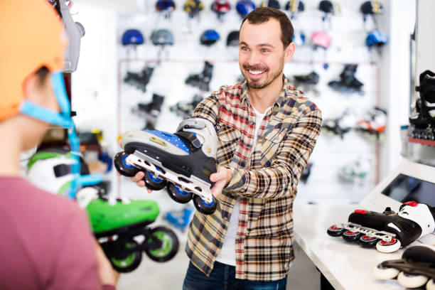 istock Smiling male demonstrating roller-skates to boy 832681726