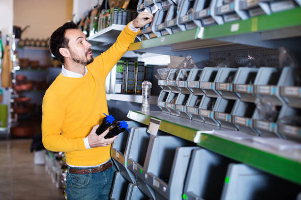 istock Man choosing various tools in garden equipment shop 832681814