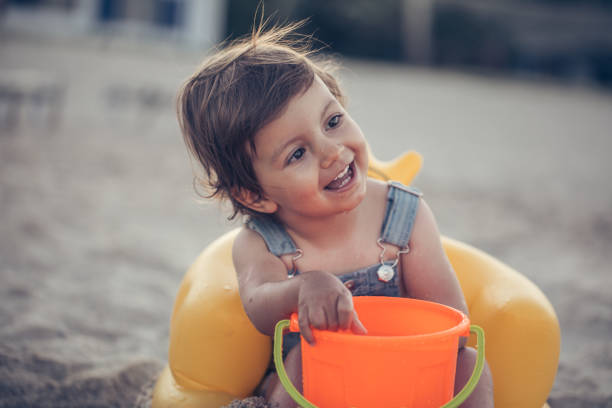 One child, playing alone on the beach in sand.