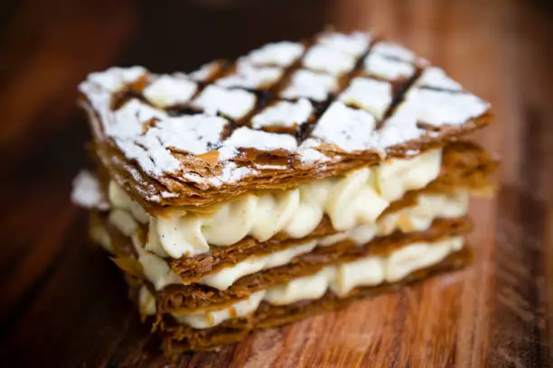 A French pastry mille-feuille made of several layers of puff pastry usually filled with cream or custard, and topped with icing or sugar. The mille-feuille, vanilla slice, custard slice, also known as the Napoleon, is a French pastry whose exact origin is unknown.