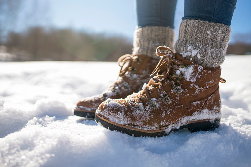 A pair of mountaineer's boots in the snow, close-up shot.