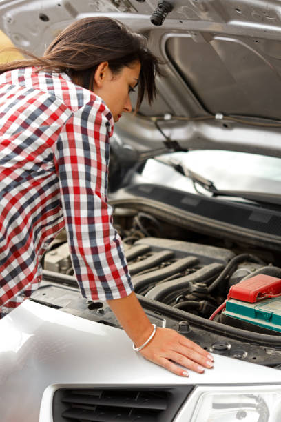 istock Woman looking at the broken car's engine 832741772