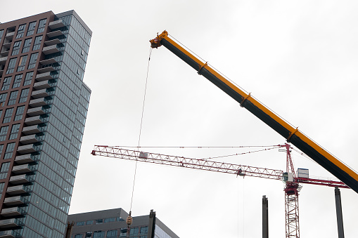 Construction zone. Crane and building construction site against blue sky.